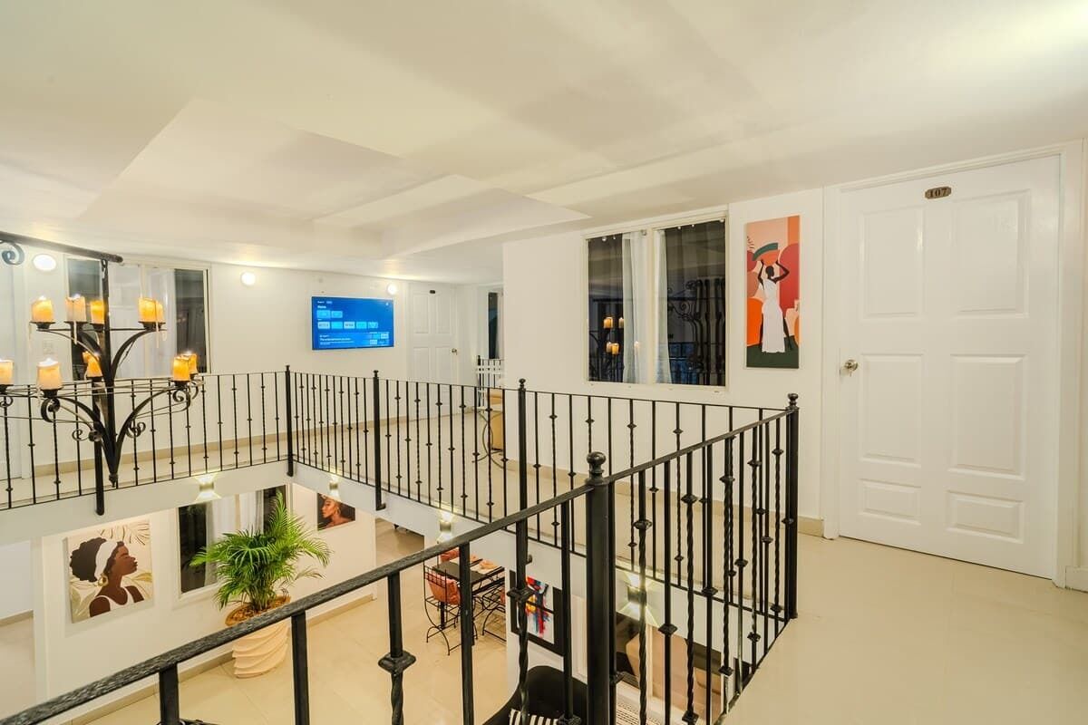 Ett rymligt interiört utrymme med en balkong, en platt-TV och konstverk på väggarna.
