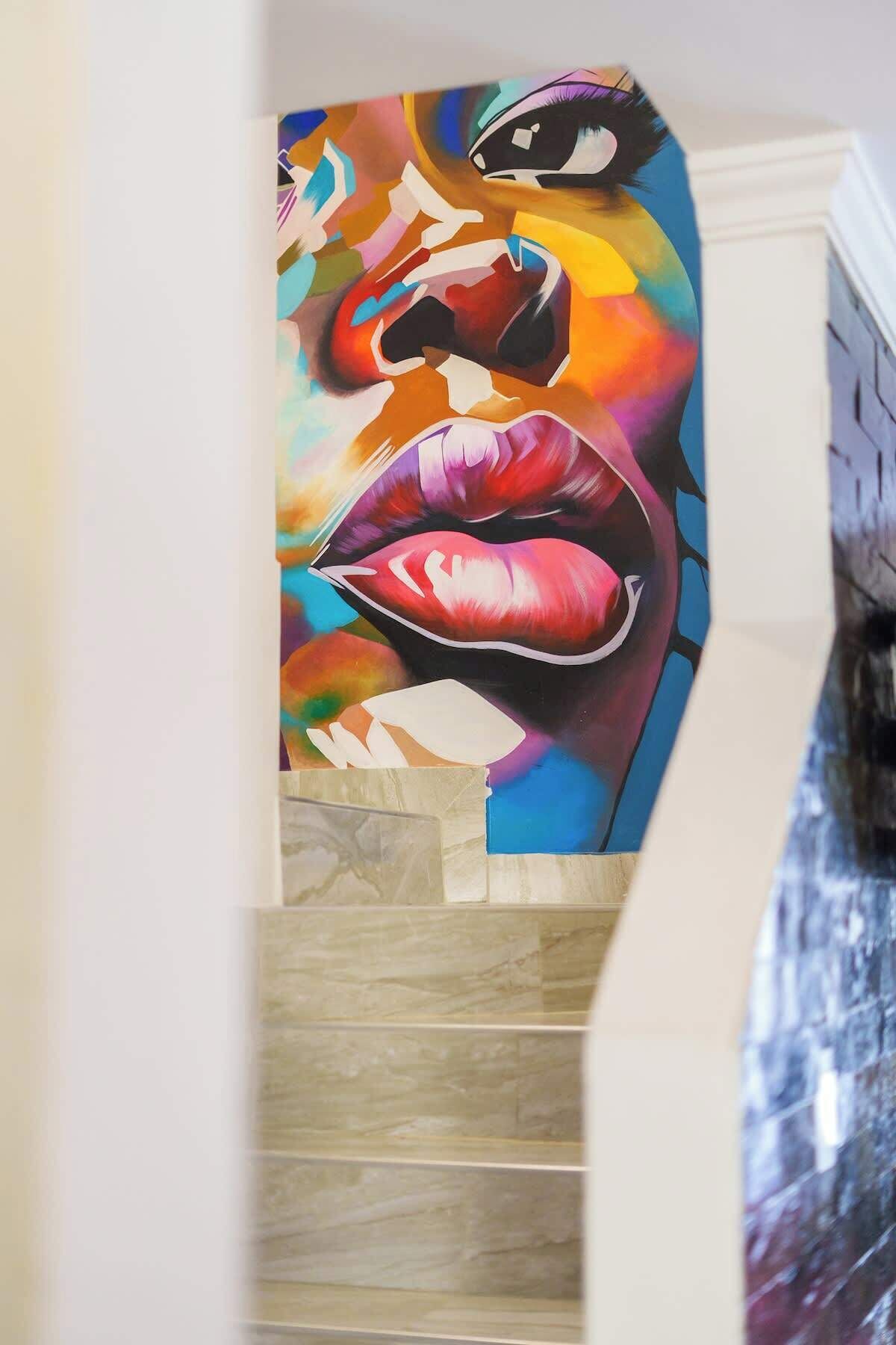 A staircase with a colorful mural on the wall.