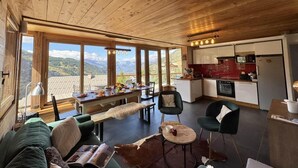 A cozy cabin interior with a dining area, kitchen, and large windows offering mountain views. - View mountain, terrace, parking, ski locker, 80m², Vars (Vars)