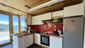 A modern kitchen with white cabinets, a red backsplash, and a large window overlooking a scenic view. - View mountain, terrace, parking, ski locker, 80m², Vars (Vars)