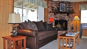 A cozy living room with a leather sofa, a small wooden table, and a fireplace. - Southern Comfort Big Bear Lake (Big Bear Lake)