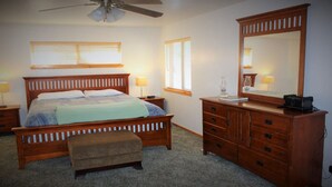A bedroom with a wooden bed, a nightstand, a dresser, and a ceiling fan. - Aspen Glen Big Bear Lake (Big Bear Lake)