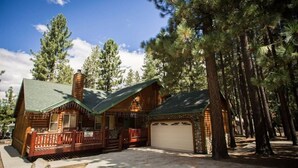 A log cabin with a green roof, a porch, and a garage. - DeCarlo House Big Bear Lake (Big Bear Lake)