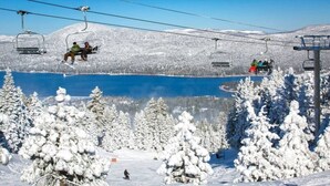 A ski lift with passengers, a snowy landscape, and a lake. - DeCarlo House Big Bear Lake (Big Bear Lake)