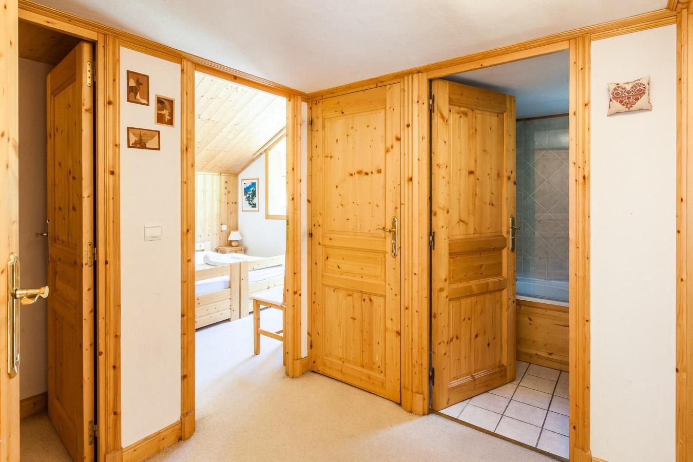 A wooden room with a bed, a small table, and a shower area.