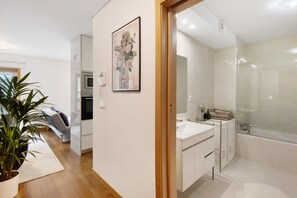 Ein modernes Badezimmer mit einer Badewanne, einem Waschbecken und einem Spiegel.