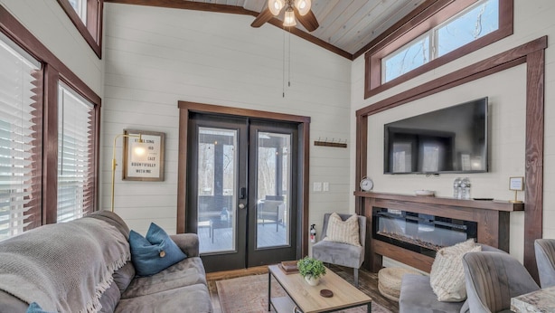 A spacious living room with a fireplace, comfortable seating, and a large TV.
