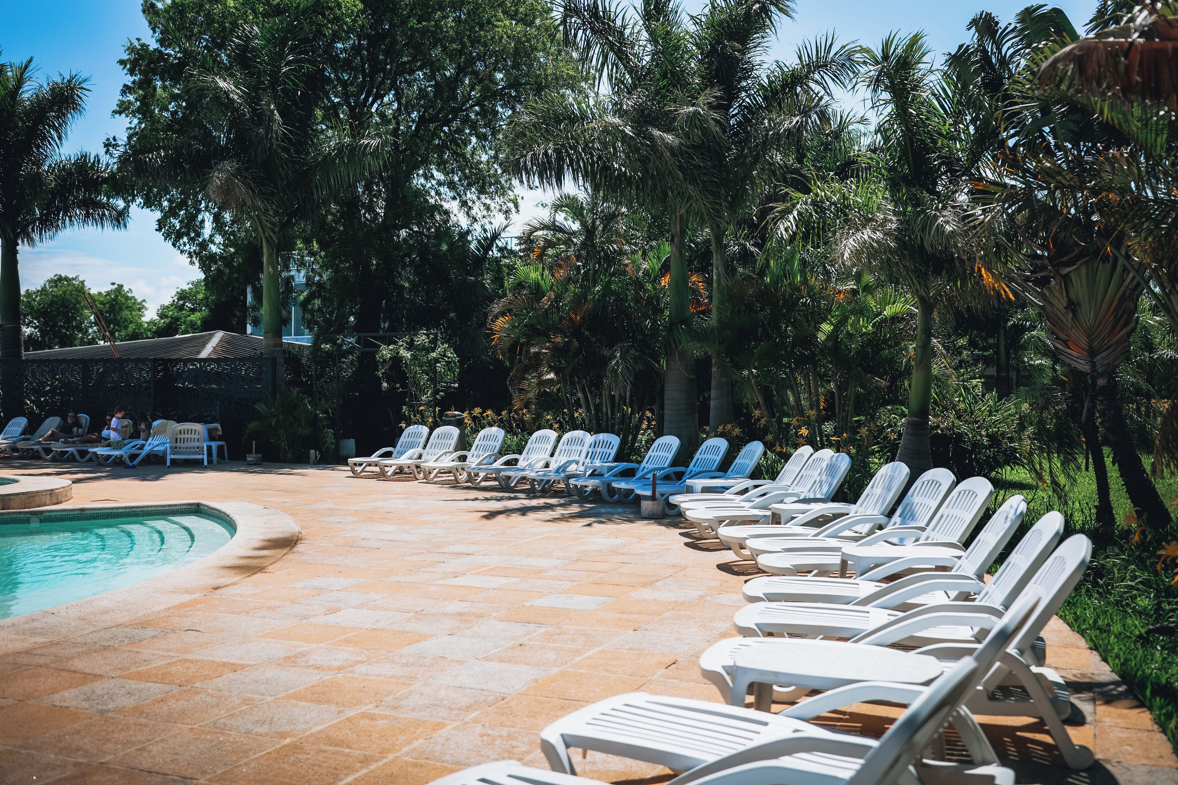 A poolside area with lounge chairs and a swimming pool.