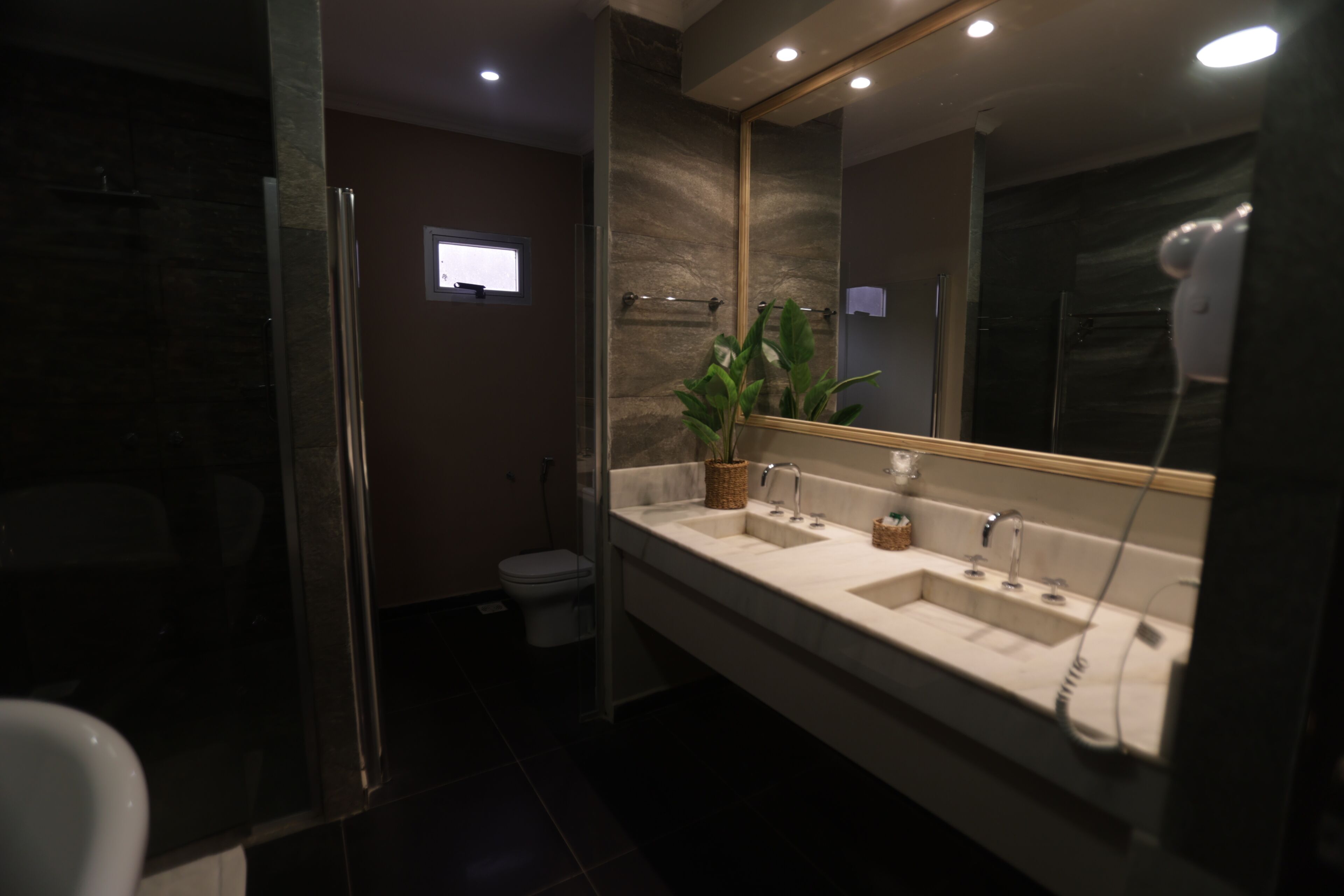 A modern bathroom with a glass shower enclosure, a double sink vanity, and a large mirror.