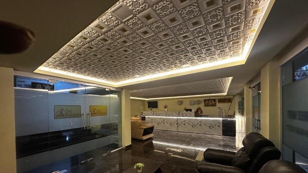 Un vestíbulo moderno con mostrador de recepción, asientos de cuero y un techo decorativo.