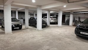Un aparcamiento de varios niveles con pilares de hormigón y suelo de baldosas.