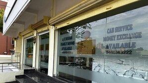 Un edificio con fachada de vidrio que anuncia habitaciones con aire acondicionado y habitaciones familiares.