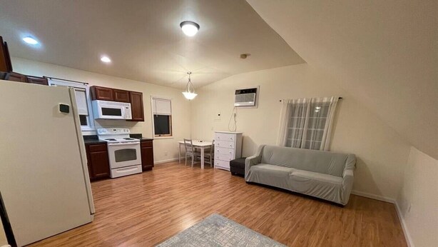 A compact living space with a kitchenette, a dining area, and a sofa.