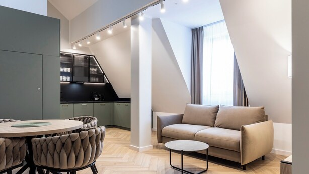 A modern apartment with a dining area, sofa, and kitchen. - Dom Pod Kotwicą (Kraków)