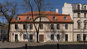 A historic building with a symmetrical facade, large windows, and a central arched entrance. - Dom Pod Kotwicą (Kraków)