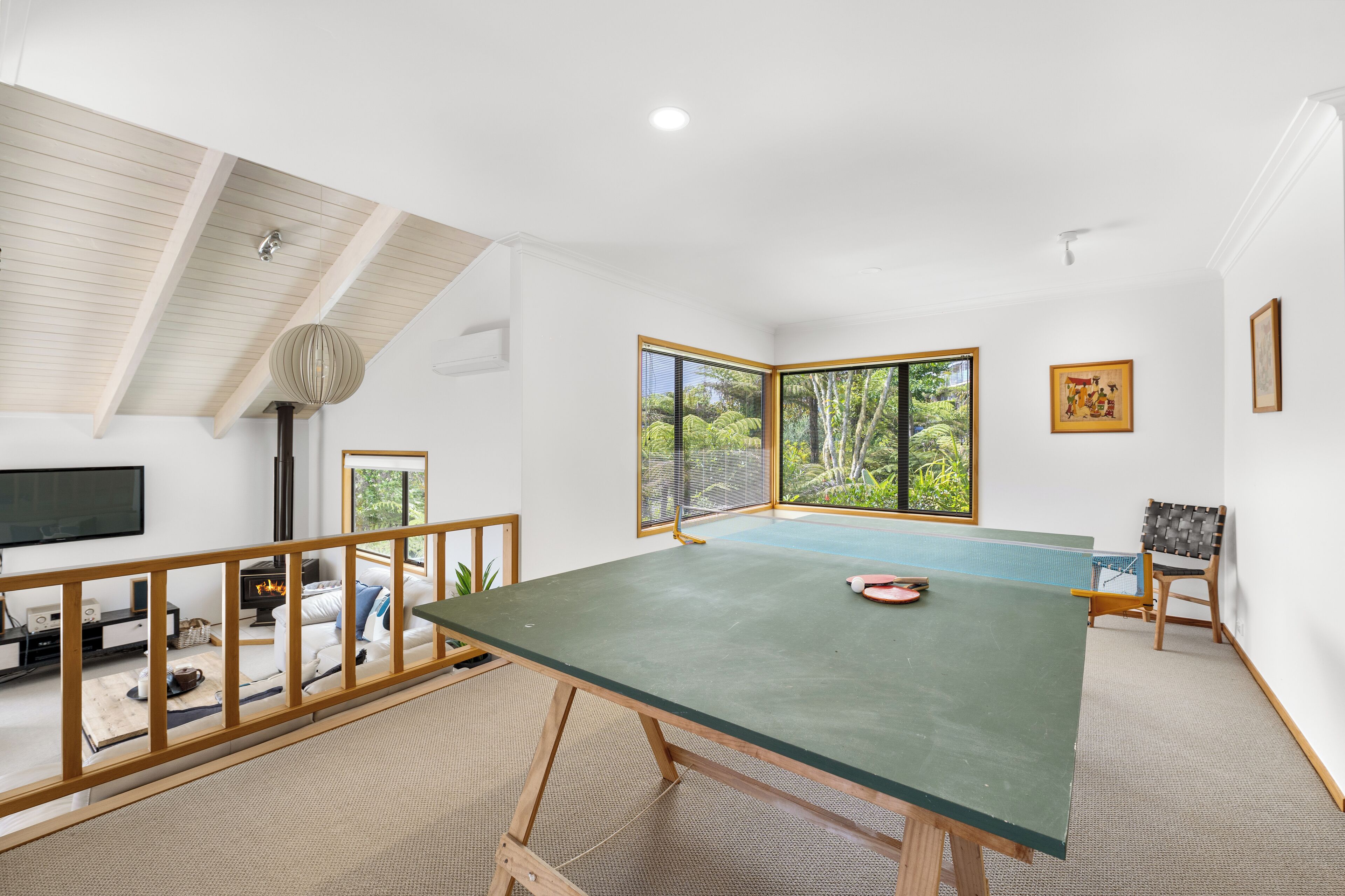 Una habitación amplia con una gran mesa verde, una silla de madera y un televisor en la pared.