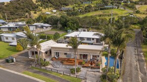 Una casa moderna de dos pisos con un patio, piscina y vistas del vecindario.