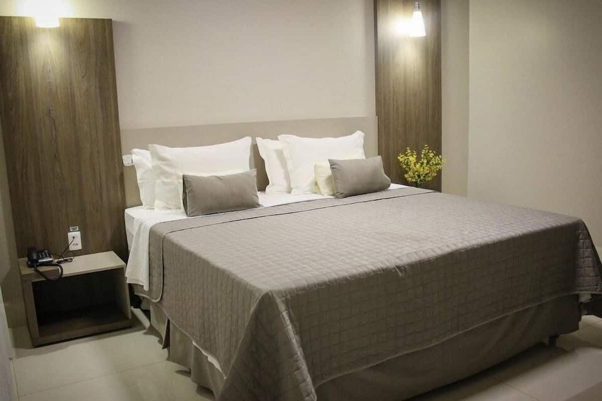 Ein modernes Schlafzimmer mit einem großen Bett, einem Nachttisch und einem Beistelltisch.