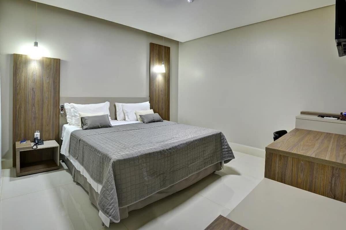 Ein modernes Schlafzimmer mit einem großen Bett, Nachttischen und einem Holztisch.