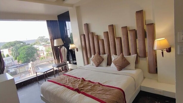 Une chambre d’hôtel moderne, dotée d’un grand lit, d’un bureau et offrant une vue sur la ville.