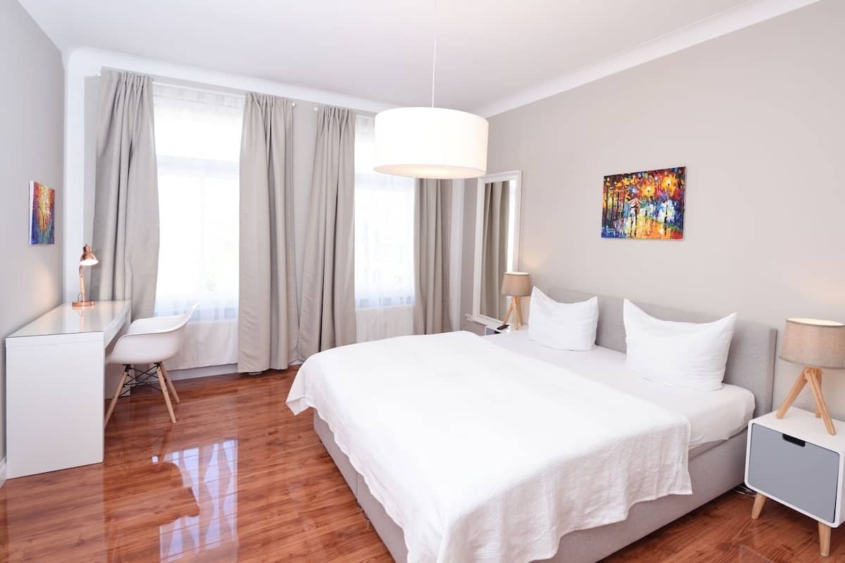 Una habitación de hotel moderna con una cama grande, un escritorio y una silla.