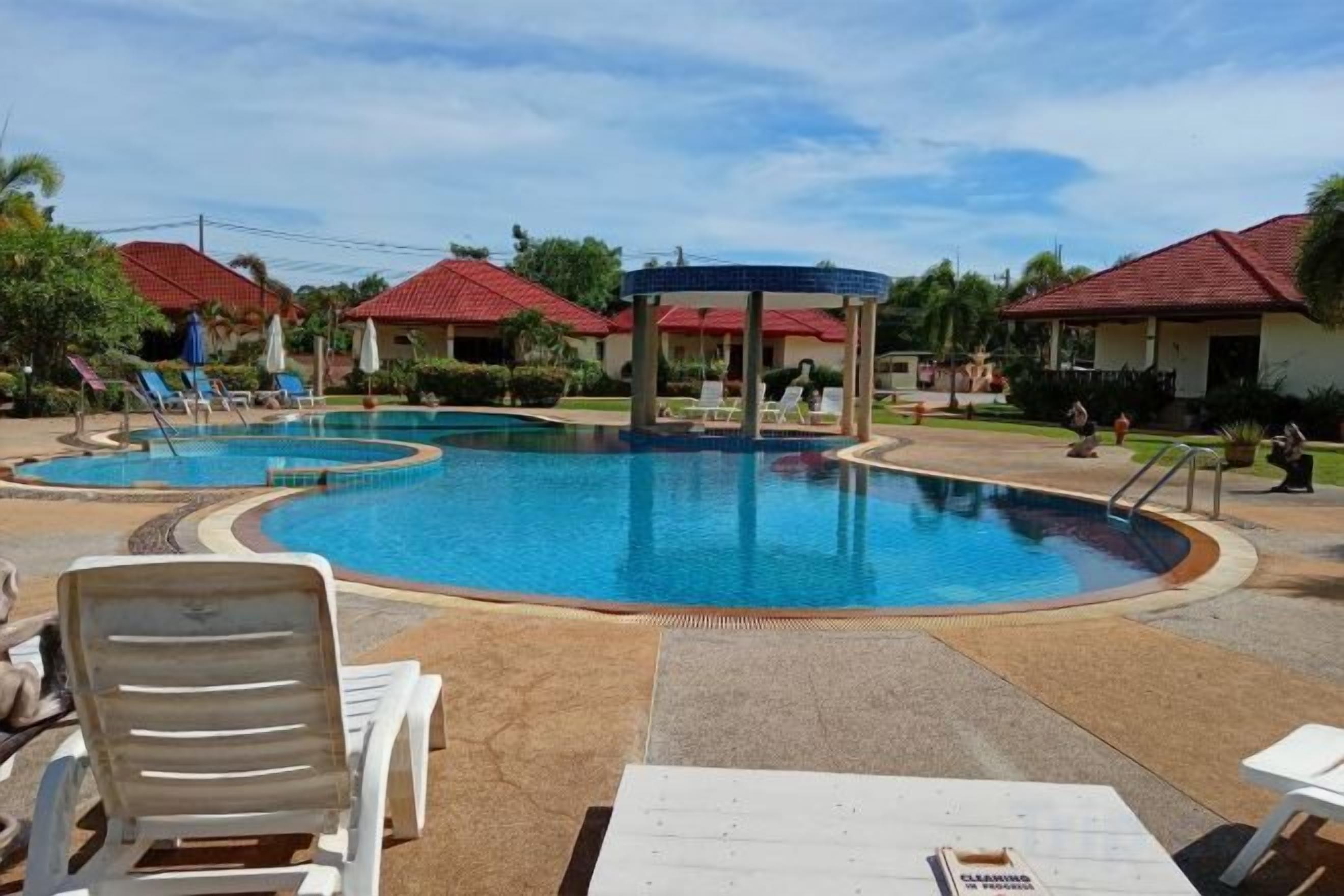 Une piscine dotée de chaises longues et d’un espace de repos abrité.