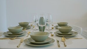 A dining table set with multiple bowls, plates, and cutlery, arranged neatly.