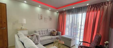 A modern living room with a sofa, armchair, and a small table.