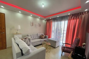 Uma sala de estar moderna com sofá, poltrona e uma mesinha.