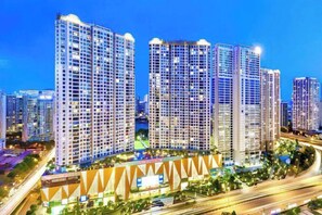 Un complexe hôtelier composé de plusieurs immeubles de grande hauteur, doté d’un atrium central et d’une zone environnante bien éclairée.