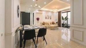 Ein modernes Wohnzimmer mit einer Couch, einem Couchtisch und einem Essbereich mit Stühlen und einem Glastisch.