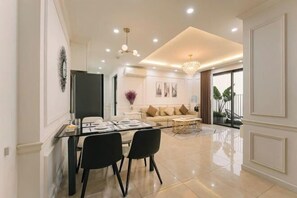 Ein modernes Wohnzimmer mit einer Couch, einem Couchtisch und einem Essbereich mit Stühlen und einem Glastisch.