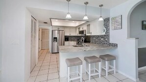 A modern kitchen with a central island, stainless steel appliances, and pendant lighting. - Beautiful 3-bedroom Pool home on Canal in wonderful Rotonda West, Close to Beach (Rotonda West)