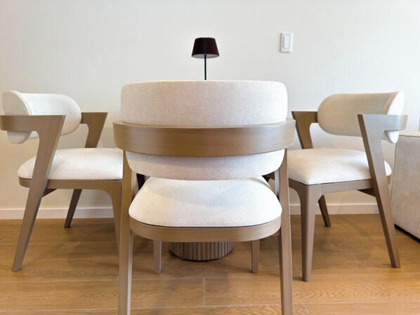 A modern, multi-tiered chair with a textured fabric seat and a wooden frame.