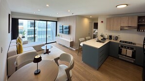 A modern apartment with a dining area, kitchen, and a balcony with a view of the city. - Luxury Stay Miraflores | Entre Marriott & Pullman (Miraflores)