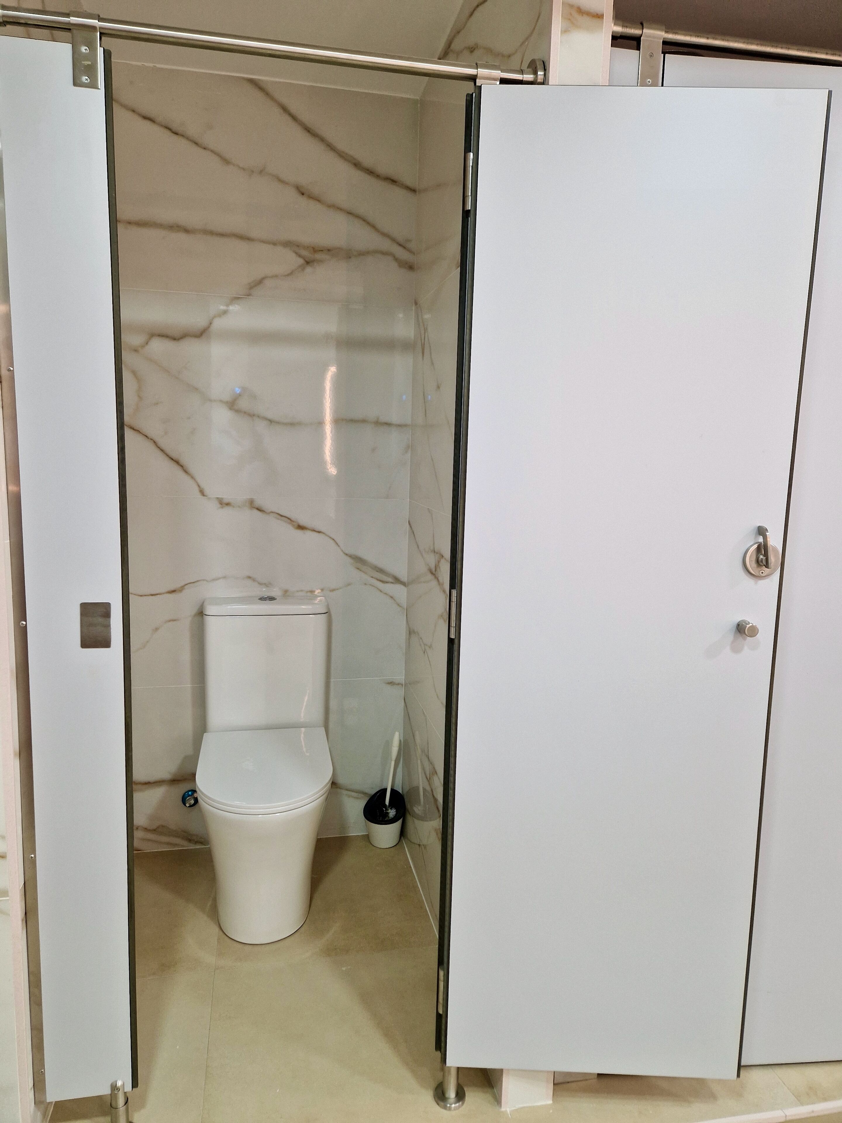 Un baño con inodoro, bidé y un armario blanco.