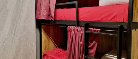 A bunk bed room with wooden walls and a light-colored floor.