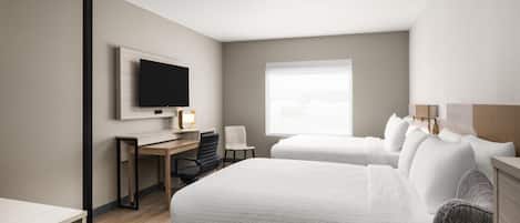 A modern hotel room with a bed, a desk, a chair, a TV, and a window.