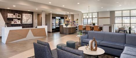 A spacious lobby with a reception desk, seating area, and a view of the outdoors.
