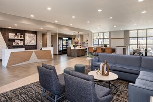 A spacious lobby with a reception desk, seating area, and a view of the outdoors.