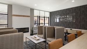 Un interior moderno con chimenea, zona de estar y un amplio ventanal con vistas.