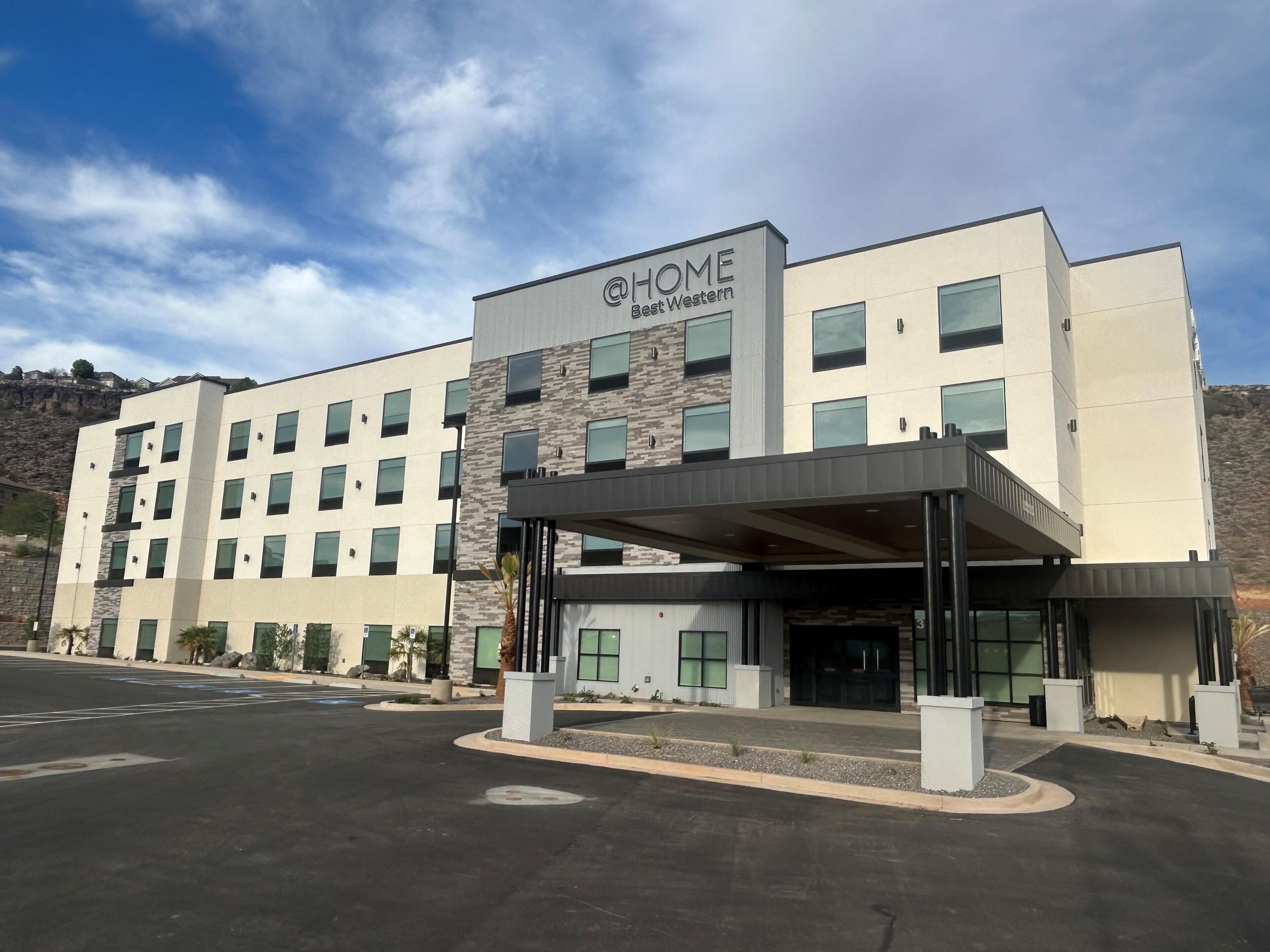 A multi-story hotel with a modern facade, a covered entrance, and a parking lot.
