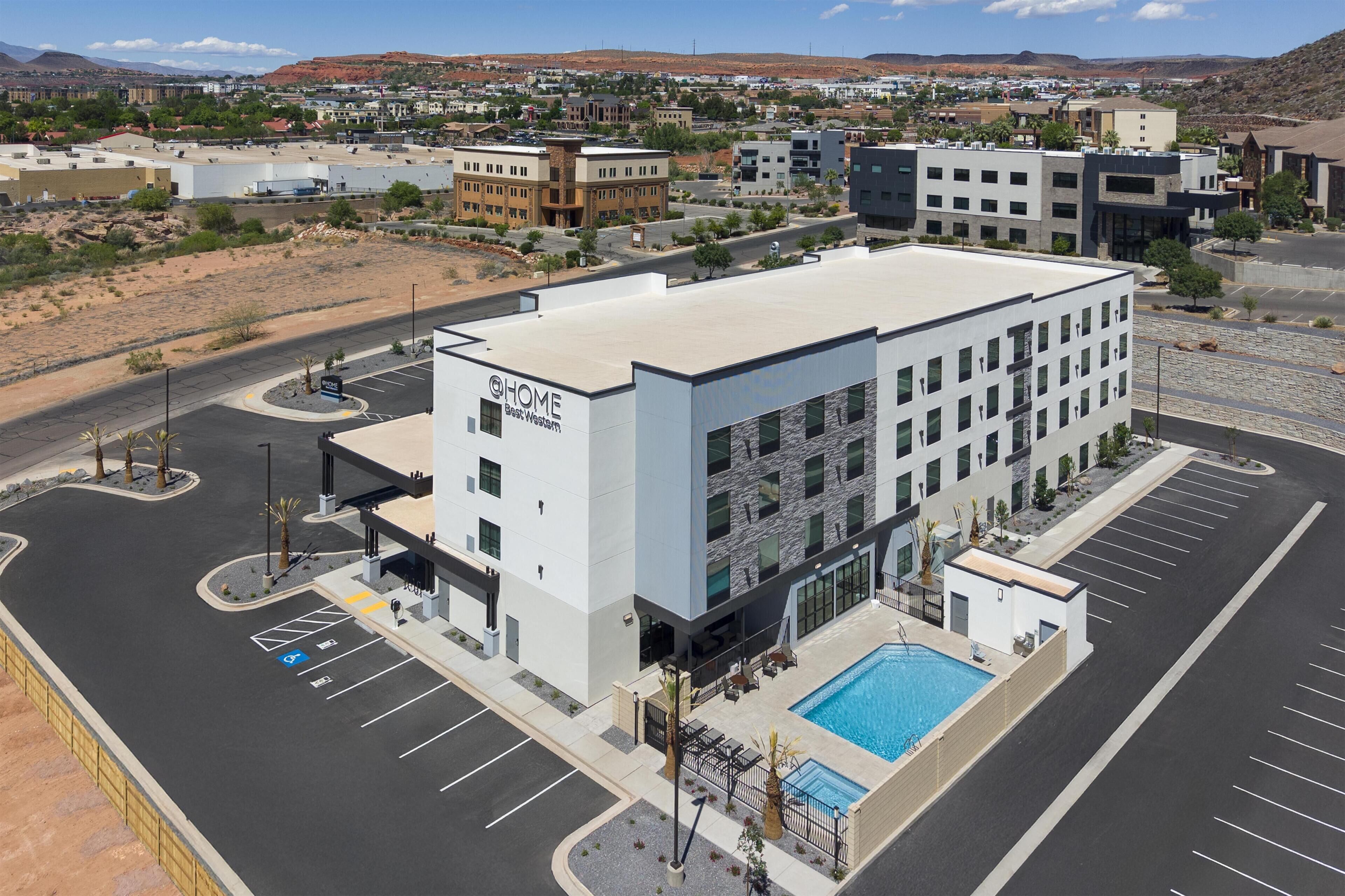Et moderne hotel med pool, parkeringsplads og udsigt over det omkringliggende område.