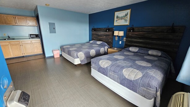 A room with two beds, a kitchenette, and a ceiling fan. - Travelers Inn and Suites (Paducah)