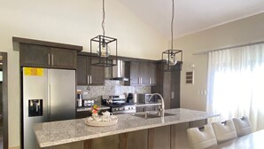 Una cocina moderna con armarios de madera oscura, electrodomésticos de acero inoxidable y encimera de granito.