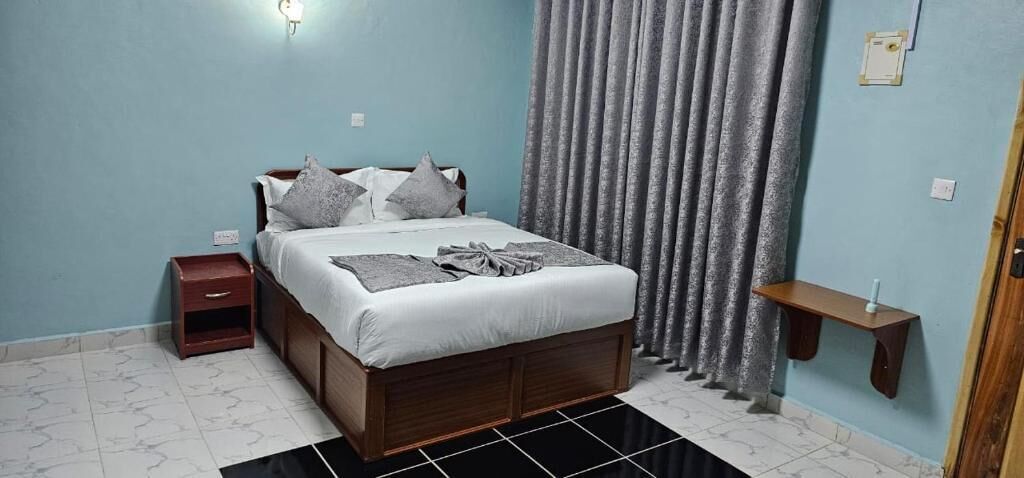 A bedroom with a bed, nightstand, and a small table.
