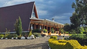 A modern building with a sloped roof and a covered porch area. - Juniper Park Resort (Ndaragwa)