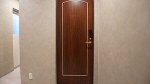 Uma porta de madeira com placa de identificação, maçaneta e fechadura.