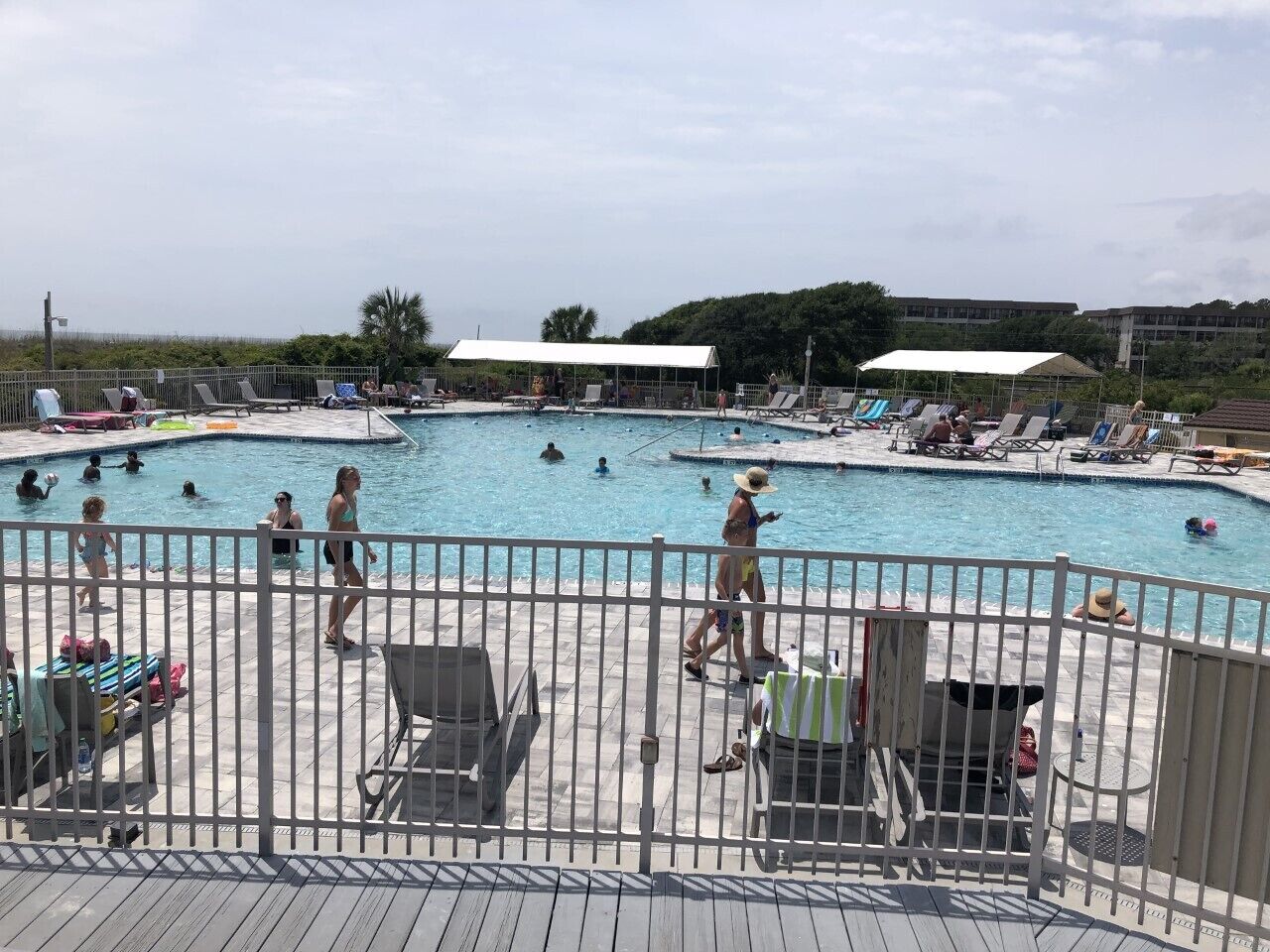 Uma área de piscina com várias piscinas, espreguiçadeiras e guarda-sóis.