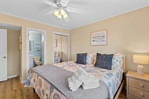 A bedroom with a bed, bedside table, and a ceiling fan. - 2-Bdrm Condo Meets Family Desires - Beachfront Resort - Full Amenities - C13 (Hilton Head Island)